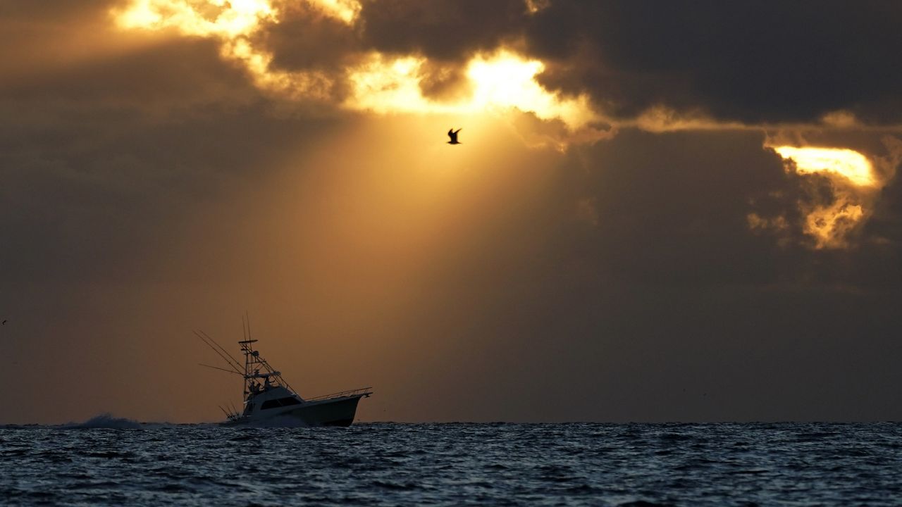 A fishing boat heads out to sea as the sun breaks through the clouds, Thursday, March 3, 2022, in Surfside, Fla. (AP/Wilfredo Lee)