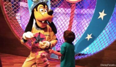 A child runs up to hug Goofy at Pete's Silly Sideshow