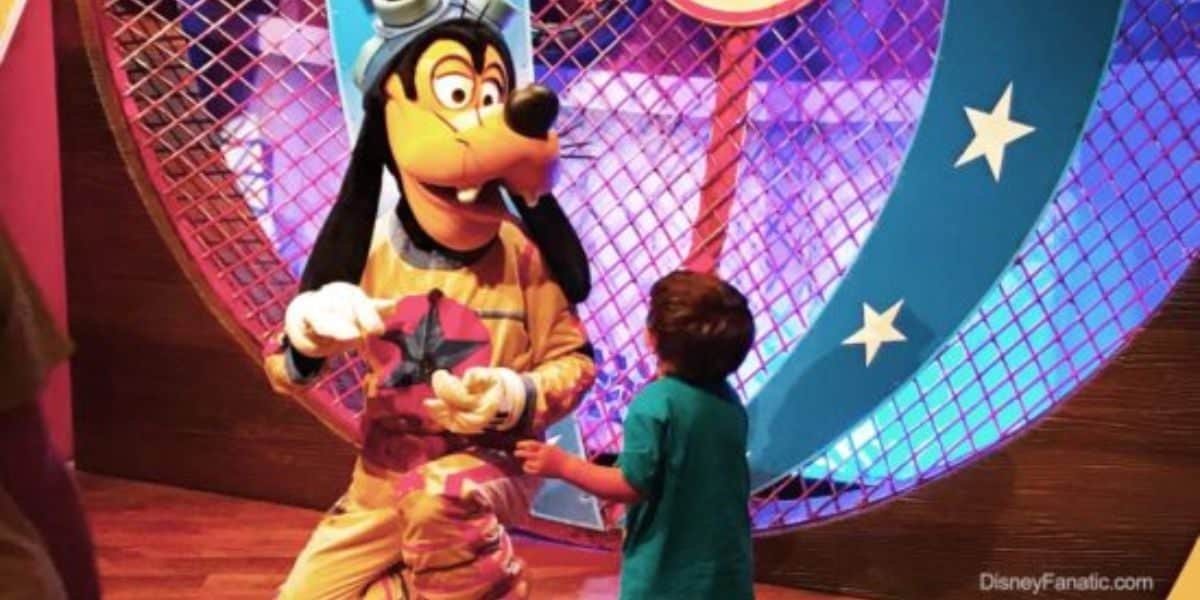 A child runs up to hug Goofy at Pete's Silly Sideshow