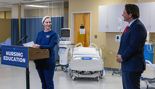SPC nursing student and Student Nurses Association president Kelsey Krebs speaks at a podium while Gov. Ron DeSantis looks on