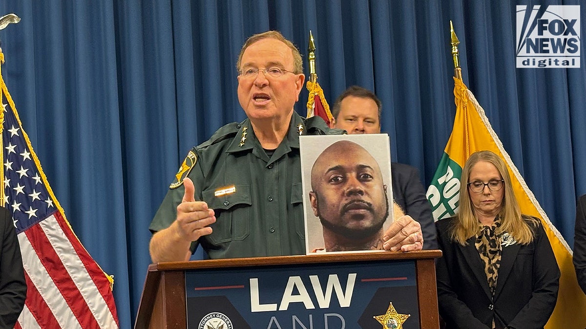 Sheriff Grady Judd holds up the booking photo of Hernando Thompson Jr.