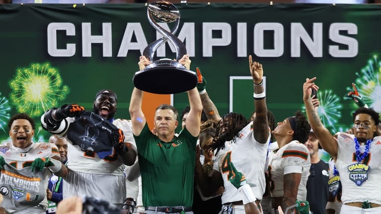 Miami head coach Mario Cristobal holds the Field Scovell Trophy...