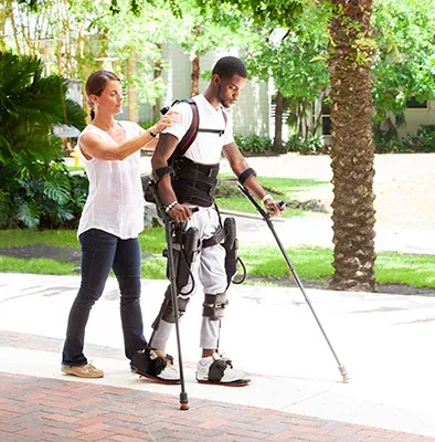 A rehabilitation provider assists a patient who is walking with crutches