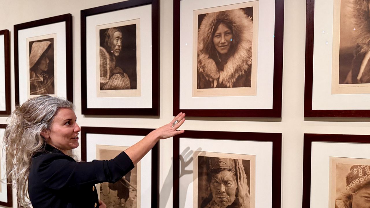 The James Museum's Associate Curator Caitlin Pendola is working to identify the unknown people in portrait work of Edward R. Curtis. Here she points out a woman with family in Florida. Photo By Virginia Johnson/Staff