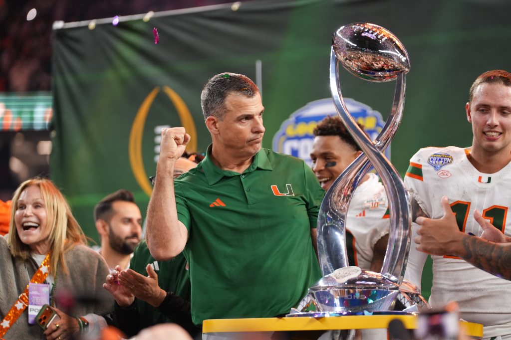 Miami Hurricanes head coach Mario Cristobal lifts the Cotton Bowl trophy.