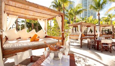 wooden cabanas and white furniture at Nikki Beach, a modern dayclub in Miami Beach