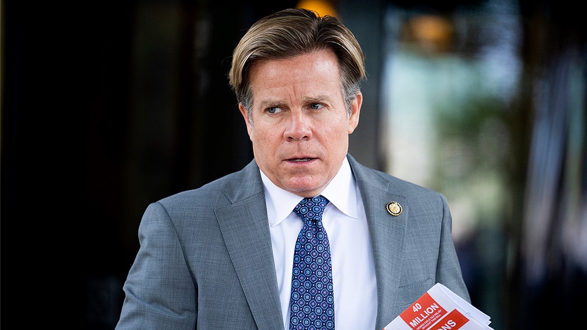 Rep. Mike Haridopolos walks away from a meeting while holding papers outside the Capitol Hill Club.