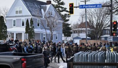 People protest as law enforcement officers attend to the scene of the shooting involving federal law enforcement agents, Wednesday, Jan. 7, 2026, in Minneapolis. (AP Photo/Tom Baker)
