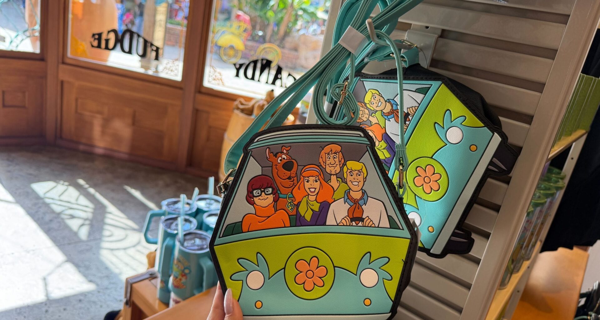 The front of this crossbody bag features the front of the Mystery Machine. Behind the windshield, we can see Fred, Daphne, and Velma riding in front with Scooby-Doo and Shaggy riding in the back.