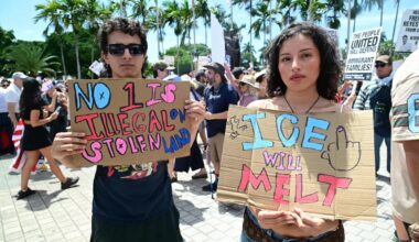 two protesters hold up painted signs reading "no 1 is illegal on stolen land" and "ICE will melt"