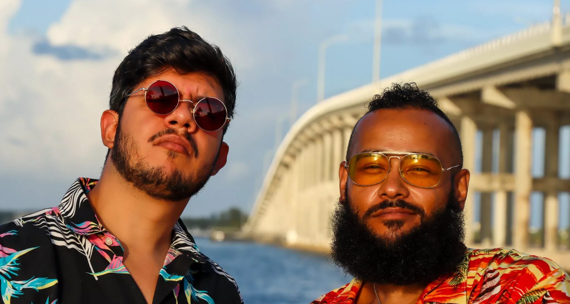 Two men wearing tropical shirts by a highway