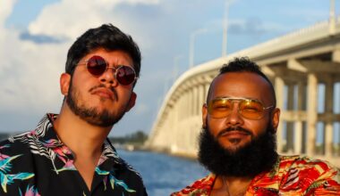 Two men wearing tropical shirts by a highway