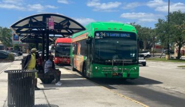 Passengers wait for a LYNX bus at a stop in Seminole County. (Spectrum News/Massiel Leyva)