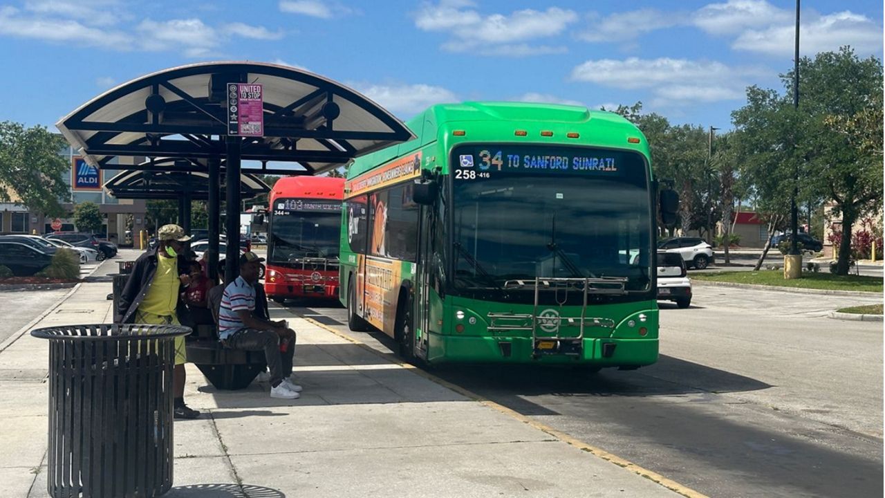 Passengers wait for a LYNX bus at a stop in Seminole County. (Spectrum News/Massiel Leyva)