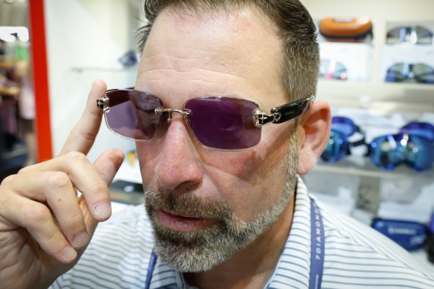 Chris McCloud shows off the Chamelo Aura Audio prismatic color-changing glasses, which can cycle through different tint colors by tapping the side of the frame with a finger, during a demo at the PGA Show Jan. 22 at the Orange County Convention Center. (Rich Pope, Orlando Sentinel)