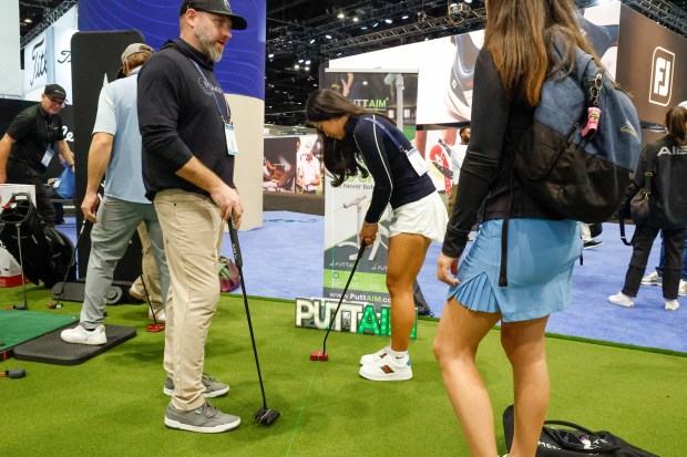 A Makefield representative demonstrates putters with PGA Show attendees on the putting green Jan. 26 at the Orange County Convention Center. (Rich Pope, Orlando Sentinel)