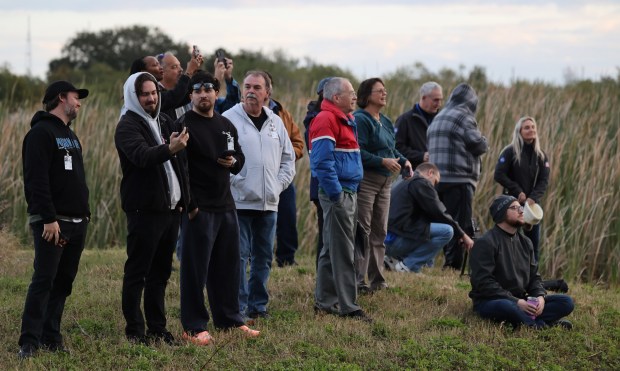People look as the Artemis II rocket rolls out of the Vehicle Assembly Building to Launch Complex 39-B at the Kennedy Space Center, on Saturday, January 17, 2026. (Ricardo Ramirez Buxeda/ Orlando Sentinel)