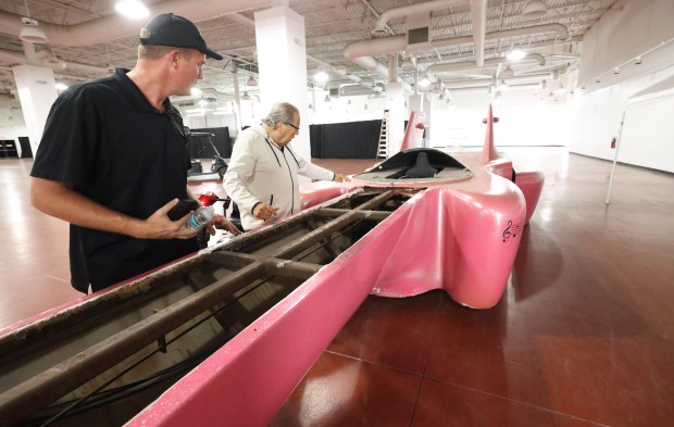 Left to Right, Kris Kirer and Michael Dezer take a look at a custom made, guitar-shaped car, that once belonged to Elvis, that just arrived at Dezerland Park Orlando, on Wednesday, Sept. 3, 2025. Orlando Auto Museum, an attraction inside Dezerland, is going to put about a million dollars of resoration into the car and have it set up where guests of the auto museum can watch the restoration process live. (Ricardo Ramirez Buxeda/Orlando Sentinel)