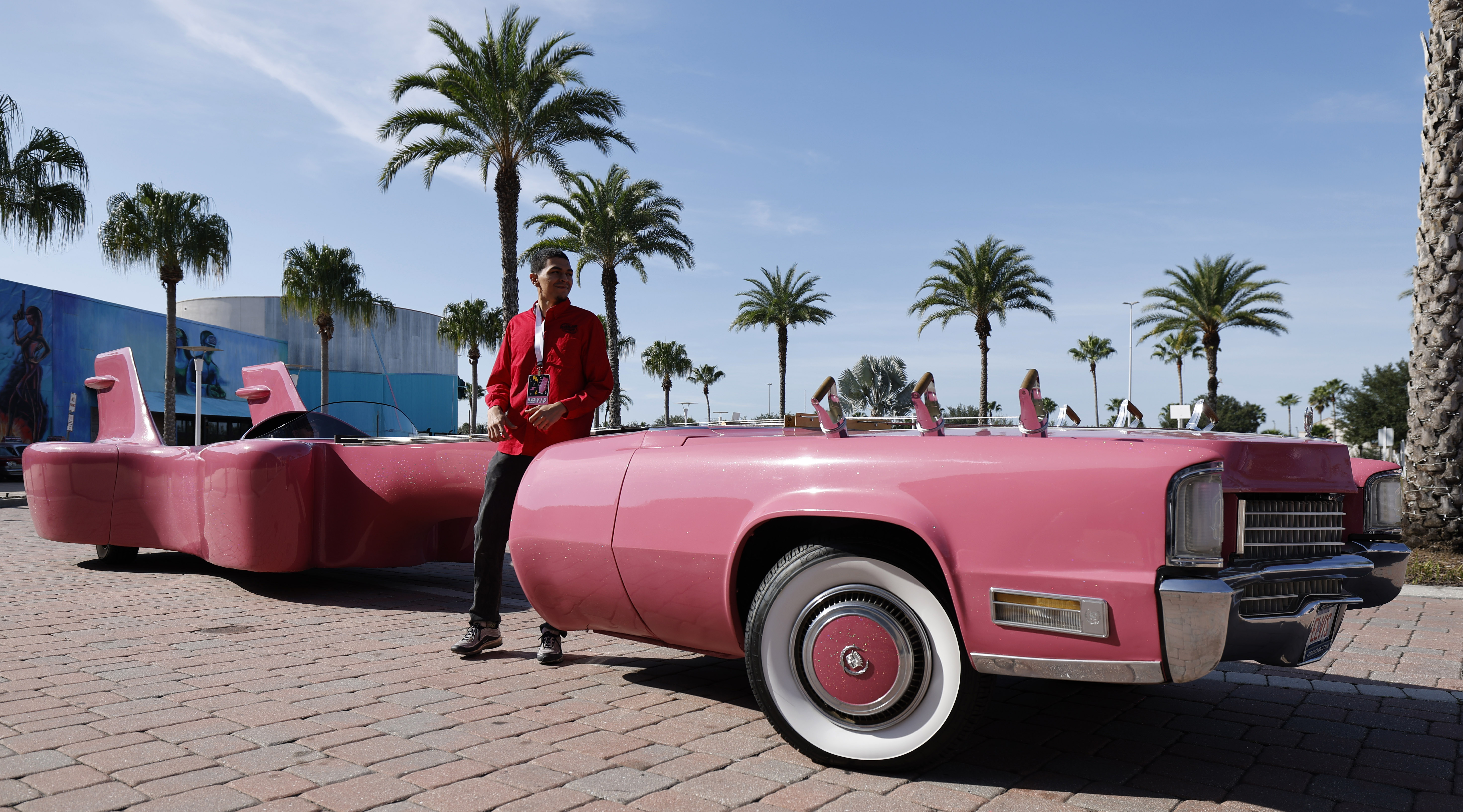 Autobody technician Richardson Sanabria poses with the restored guitar-shaped car...