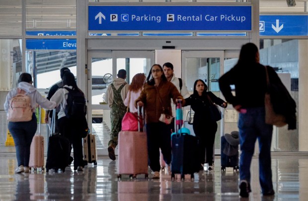 Travelers walk to the parking garage at Terminal C of the Orlando International Airport, on Tuesday, January 27, 2026. (Ricardo Ramirez Buxeda/ Orlando Sentinel)