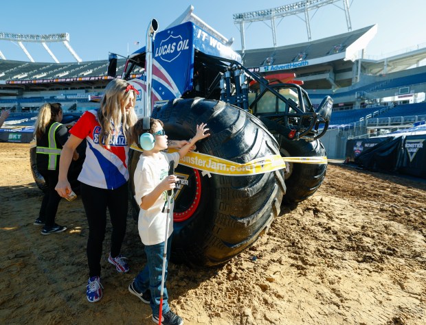 Monster Jam driver Cynthia Gauthier helps guide 10-year-old Connor Lehman to get up close to the Monster Jam truck she drives, Lucas Stabilizer, during a blind Touch-A-Truck event that brought children and teenagers from Lighthouse Central Florida a unique sensory experience with the larger-than-life trucks and their drivers on Friday, January 9, 2025.(Rich Pope/Orlando Sentinel)