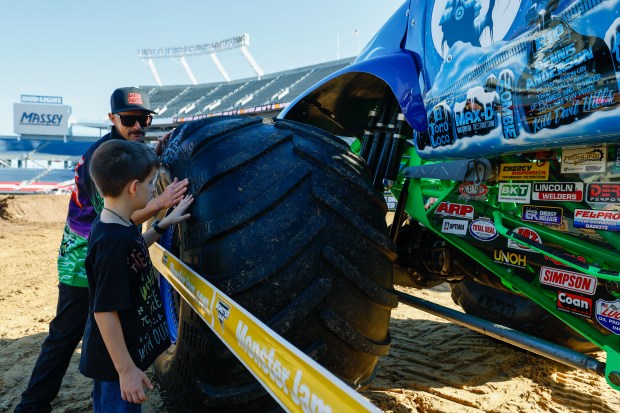 Grave Digger driver Adam Anderson and Kaiser Peters feel the details of the tires on the truck that is expected to draw cheers from fans on Saturday night. Taken during the Blind Touch-A-Truck event for kids and teenagers from Lighthouse Central Florida on Friday, January 9, 2025. (Rich Pope/Orlando Sentinel)