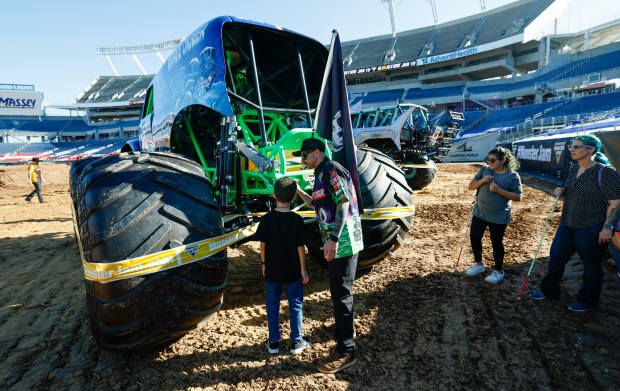 Grave Digger driver Adam Anderson and Kaiser Peters feel the details on the truck that is expected to draw cheers from fans on Saturday night. Taken during the Blind Touch-A-Truck event for kids and teenagers from Lighthouse Central Florida on Friday, January 9, 2025. (Rich Pope/Orlando Sentinel)