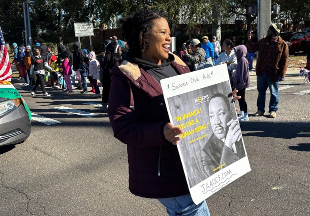 A member of the Jamaican American Association of Central Florida waves a picture of Dr. Martin Luther King, Jr., during Ocoee's 18th Annual Dr. Martin Luther King Jr. Unity Parade on Monday, January 19, 2026. (Rich Pope/Orlando Sentinel)