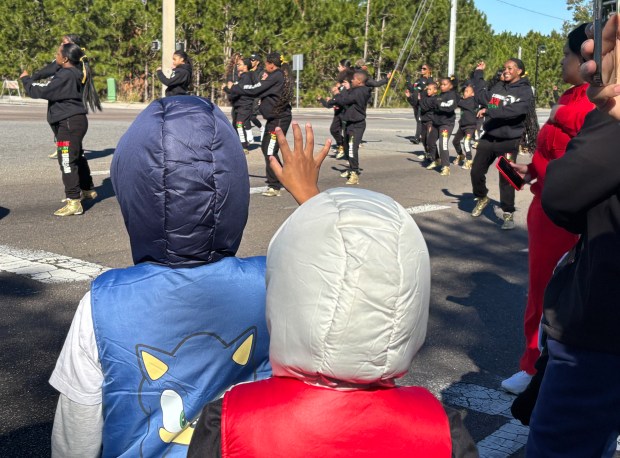 A couple of young spectators wave to the Standing Ovation Talent Group as they perform during Ocoee's 18th Annual Dr. Martin Luther King Jr. Unity Parade on Monday, January 19, 2026. (Rich Pope/Orlando Sentinel)