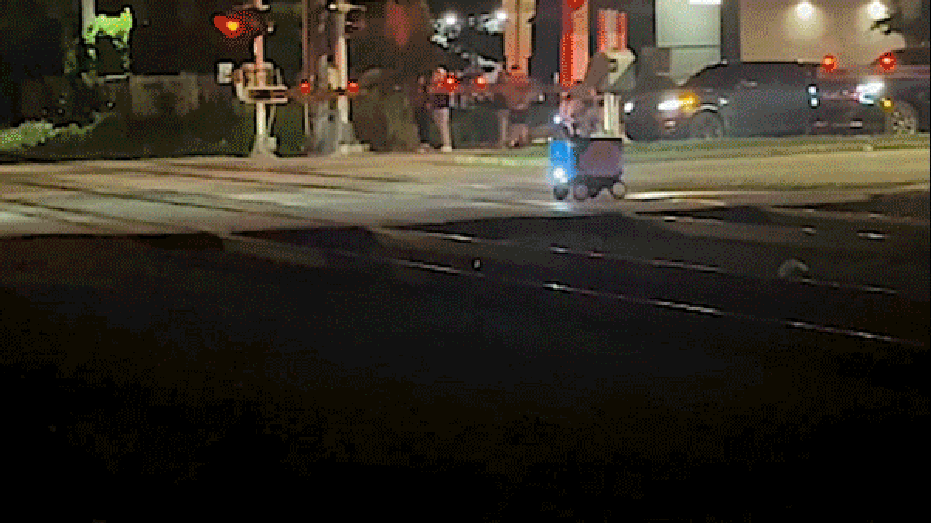 Food delivery robot is struck by a passing train at a Miami railroad crossing at night.