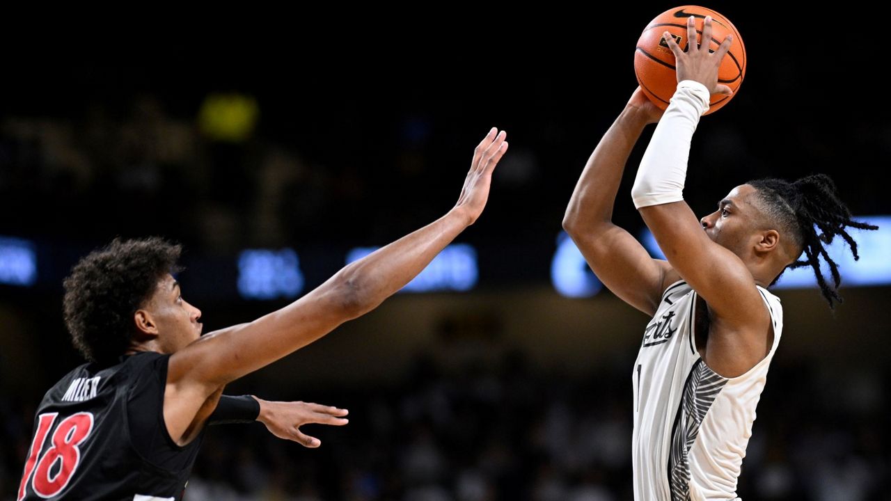 UCF guard Themus Fulks goes up to shoot the game-winning shot as Cincinnati forward Baba Miller (18) defends on Sunday, Jan. 11, 2026, in Orlando, Fla. (AP Photo/Phelan M. Ebenhack)