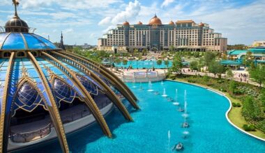 A grand hotel with domes, evoking EPCOT’s luxe resorts, overlooks a pool and pavilion—not unlike Disney castles