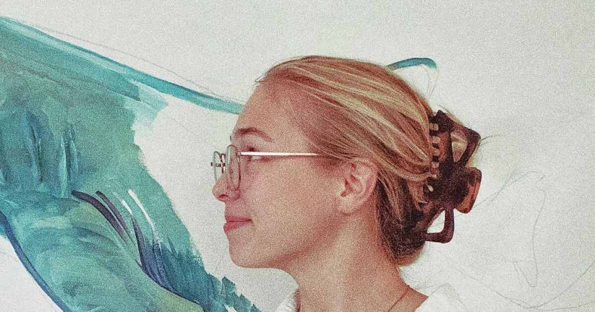 Fifth-year FGCU student Macy Noll installing 'Knowledge in Motion' mural in Wilson G. Bradshaw Library