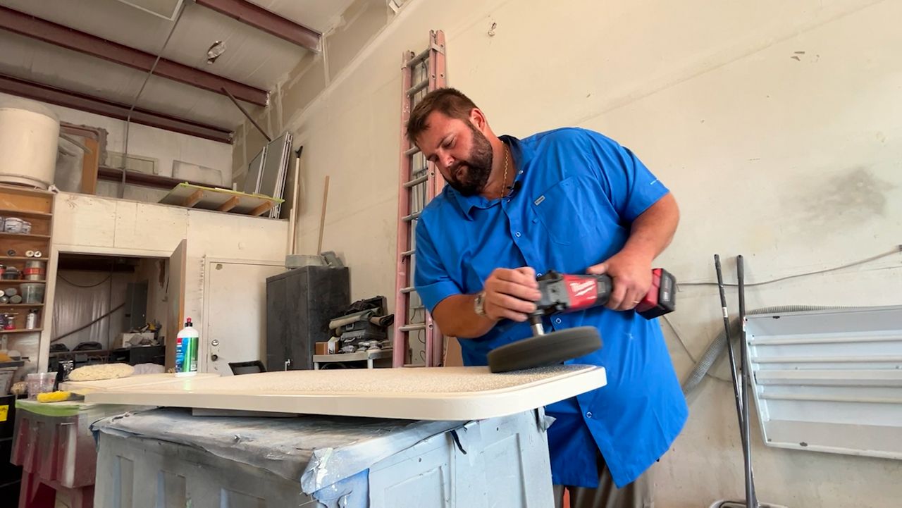 Corey McKeever, seen here working on boat parts, started a petition a month ago against the proposed cruise port. (Spectrum News/Julia Hazel)
