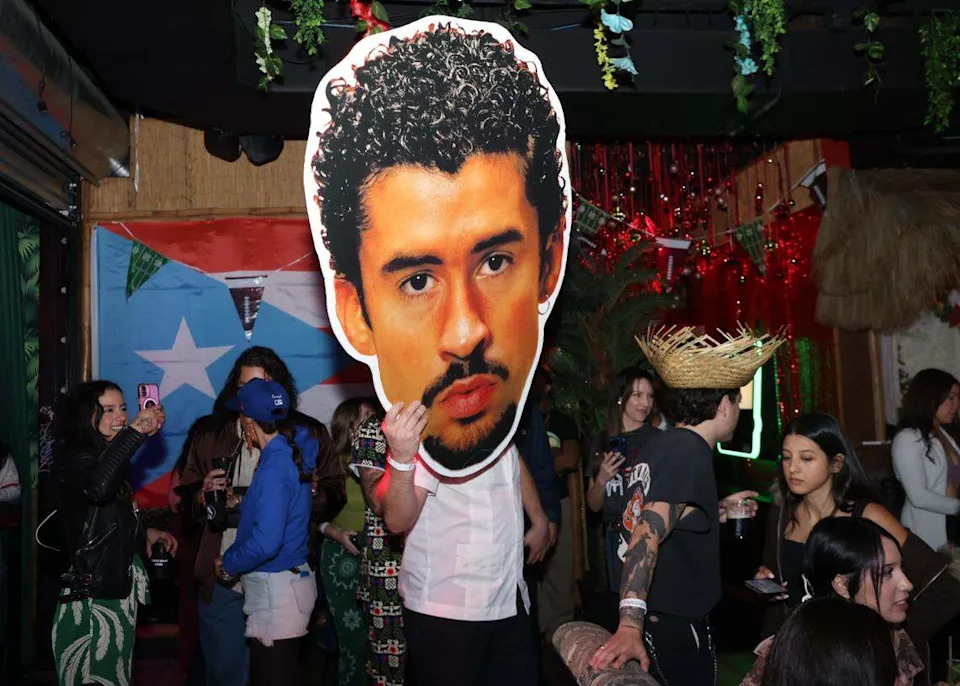 Bad Bunny head poster is carried throughout the crowded Casa Tiki during its Super Bowl watch party. 