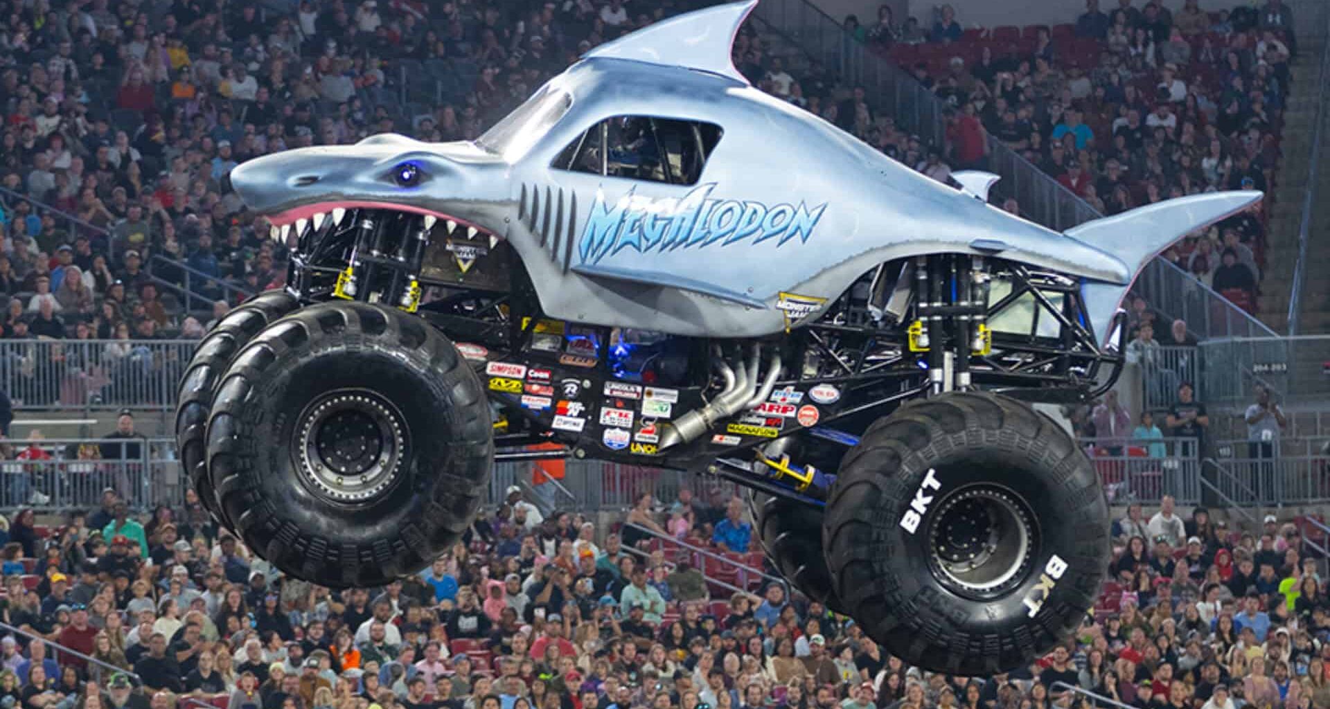 A shark themed monster truck soaring through the air