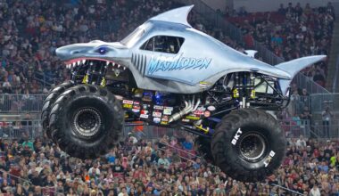 A shark themed monster truck soaring through the air