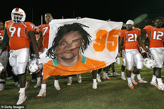 Teammates of Bryan Pata carry his image to mid-field during a 2006 home game