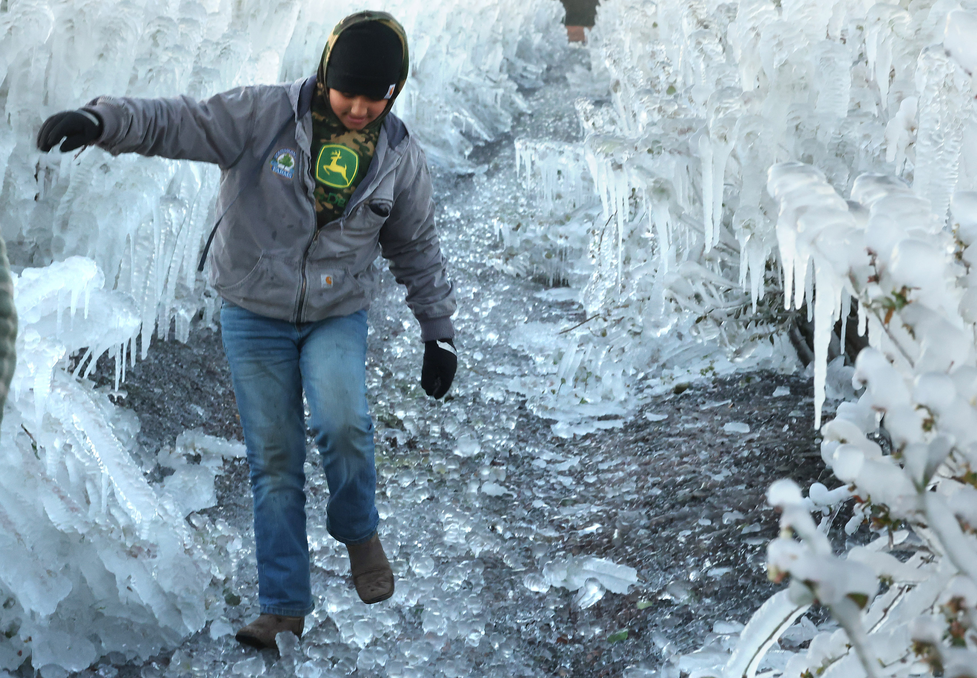 Jameson Thomas, 11, walks carefully through a frozen field of...