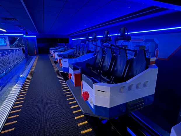 The spinning ride vehicles for Galacticoaster include a lap bar that comes down over passenger heads. Visitors access the cars via a moving sidewalk. (Dewayne Bevil/Orlando Sentinel)
