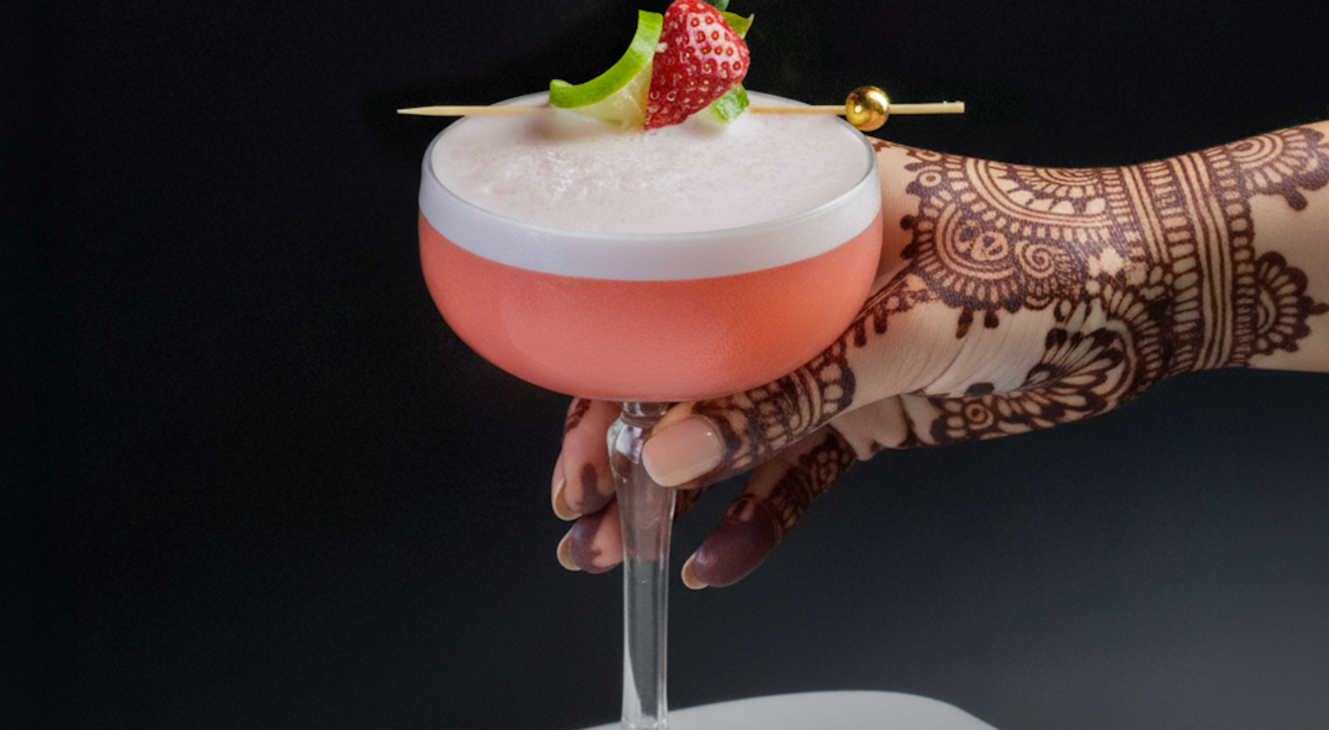 a hand with henna and a cocktail