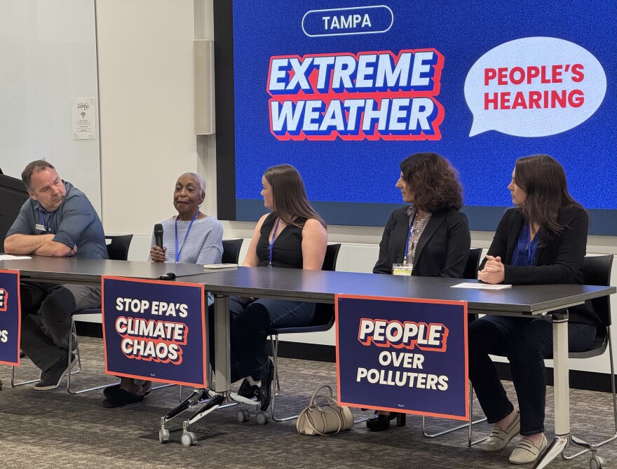 Alice Moore, Tampa resident, speaking into the microphone about preparing her apartment for a hurricane, only to lose her paid off car to floodwaters.