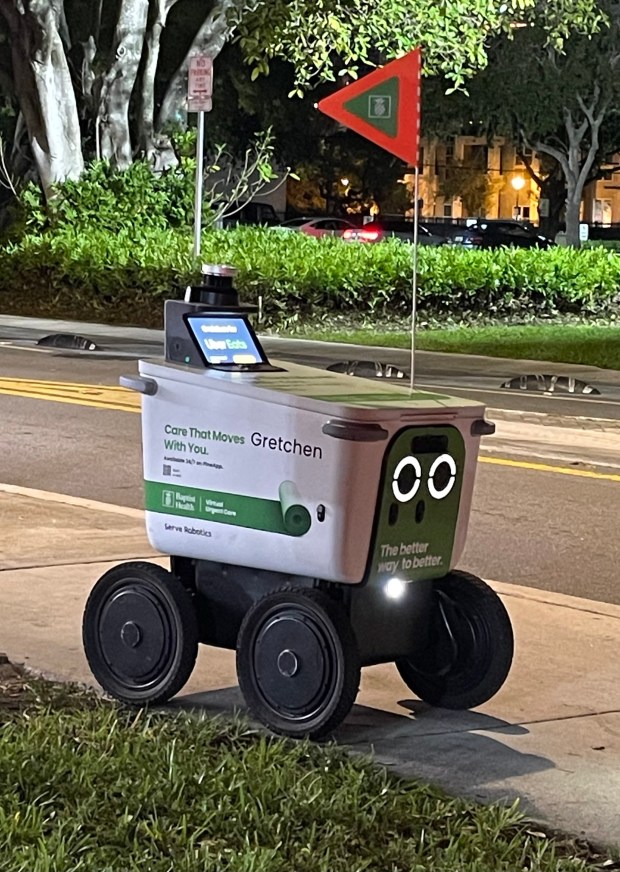 An Uber Eats branded food delivery robot makes its way down the sidewalk on Northeast First Street in downtown Fort Lauderdale, Dec. 27, 2025. (Gretchen Day-Bryant/South Florida Sun Sentinel)