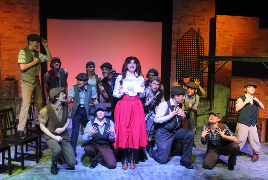 Gianna Randall as Katherine Plummer with the newsboys during their strike of her father's newspaper.