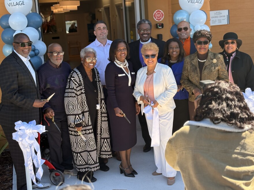 Religious leaders, housing developers and elected officials smile during a ribbon-cutting outside Zion Village senior apartments on Tuesday, Feb. 24.