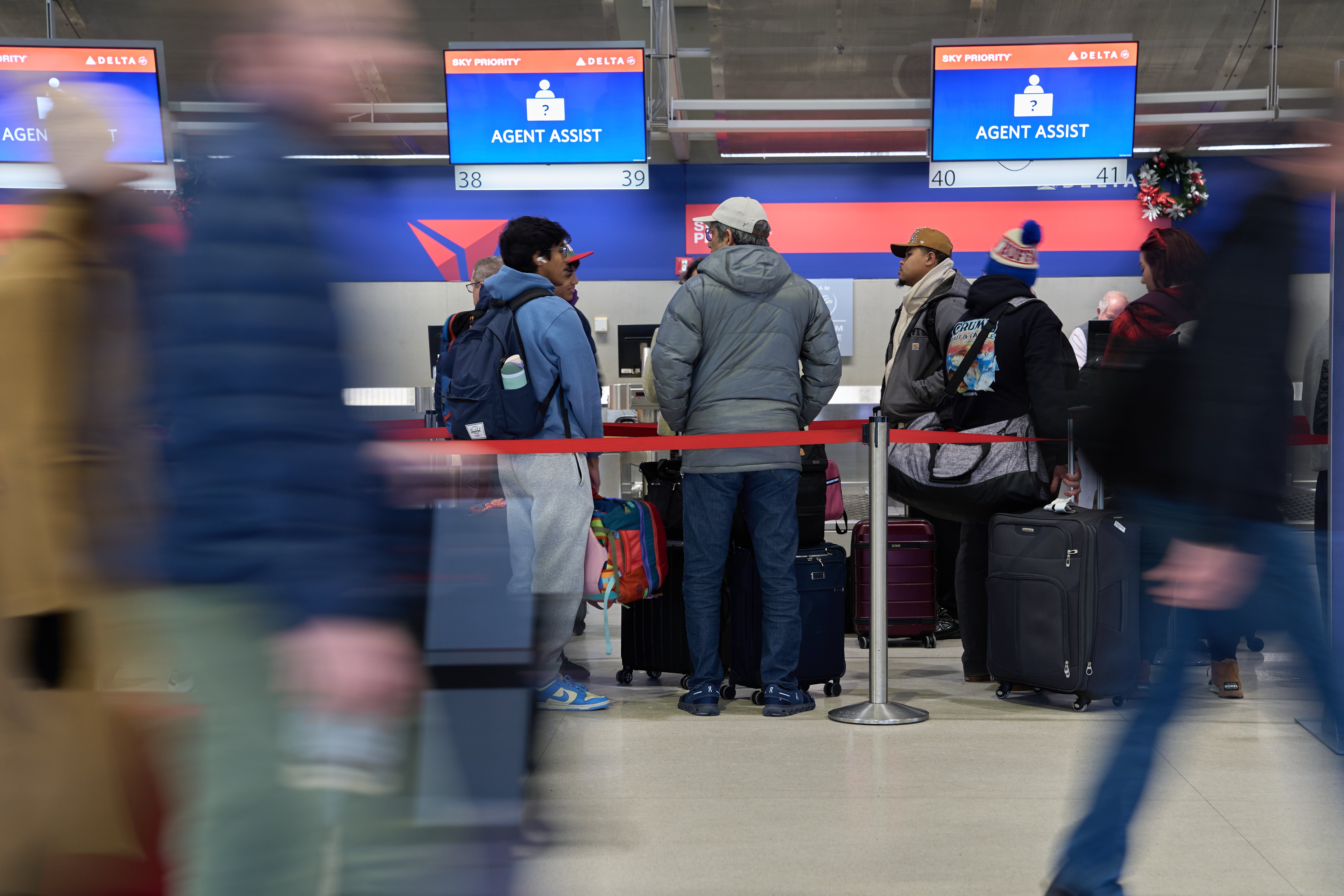 Travelers waiting to pass through an airport security checkpoint. The Tampa International Airport issued a social media post in February 2026 saying it was banning travelers from wearing pajamas to the facility