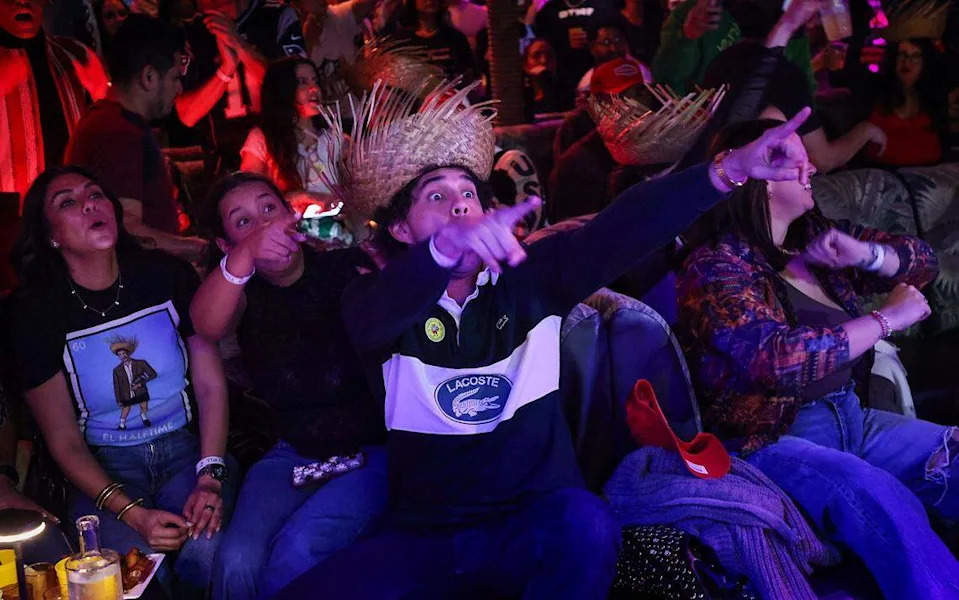 Tomas Calderaro, center, reacts with excitement as Bad Bunny begins his Half Time show. 