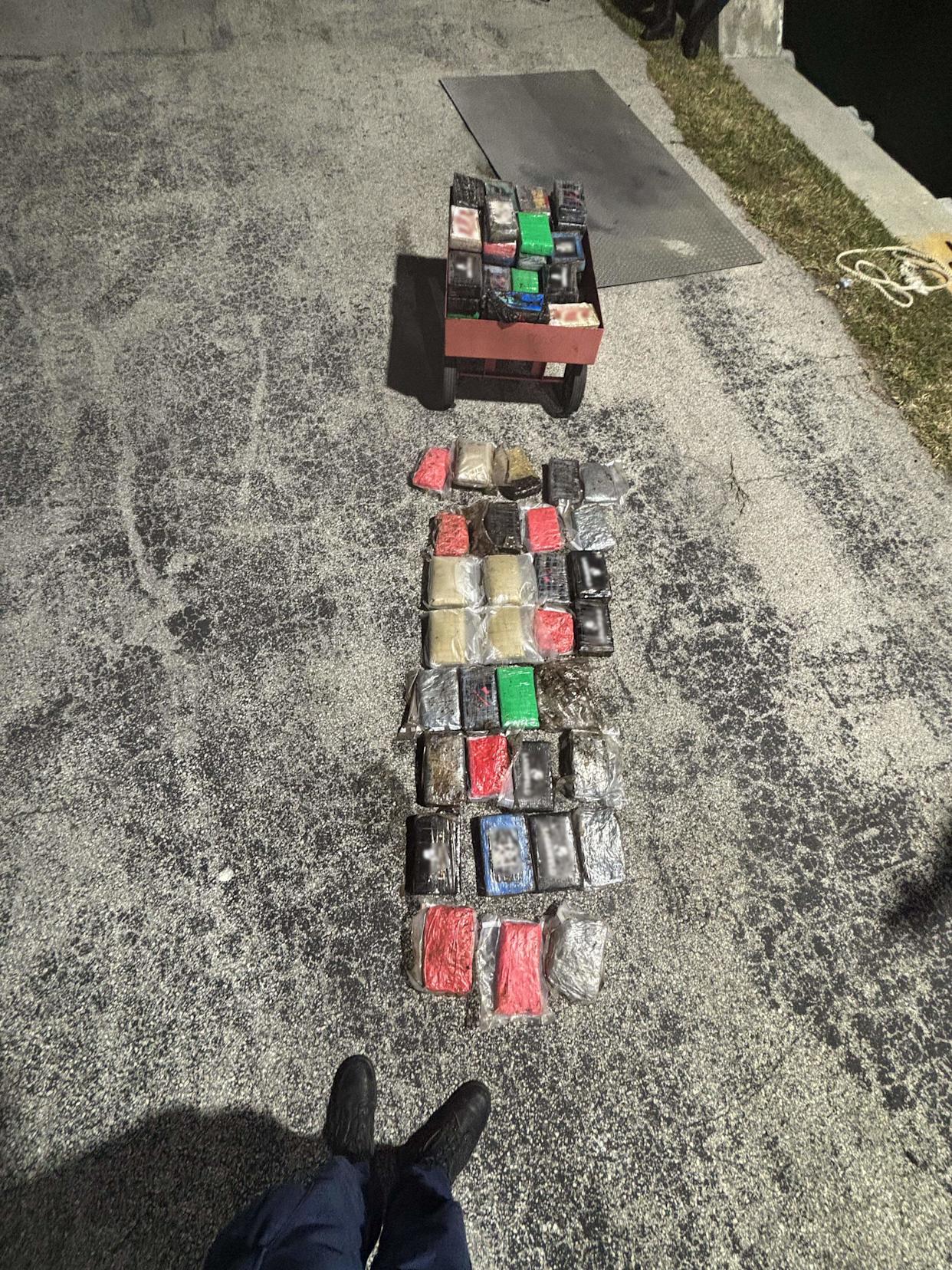 Packages of cocaine and marijuana are displayed on the ground at Coast Guard Station Fort Lauderdale Saturday, Feb. 21, 2026. The load was confiscated by a Coast Guard crew that boarded a cabin cruiser off Haulover Inlet earlier that day, according to the agency.