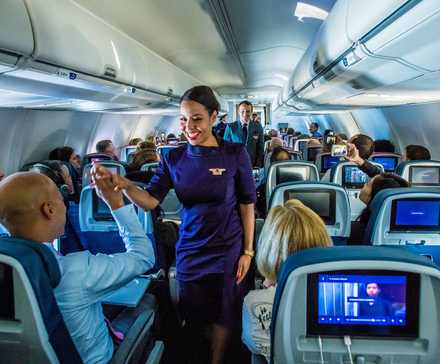 Delta Air Lines flight attendants working in the main cabin.