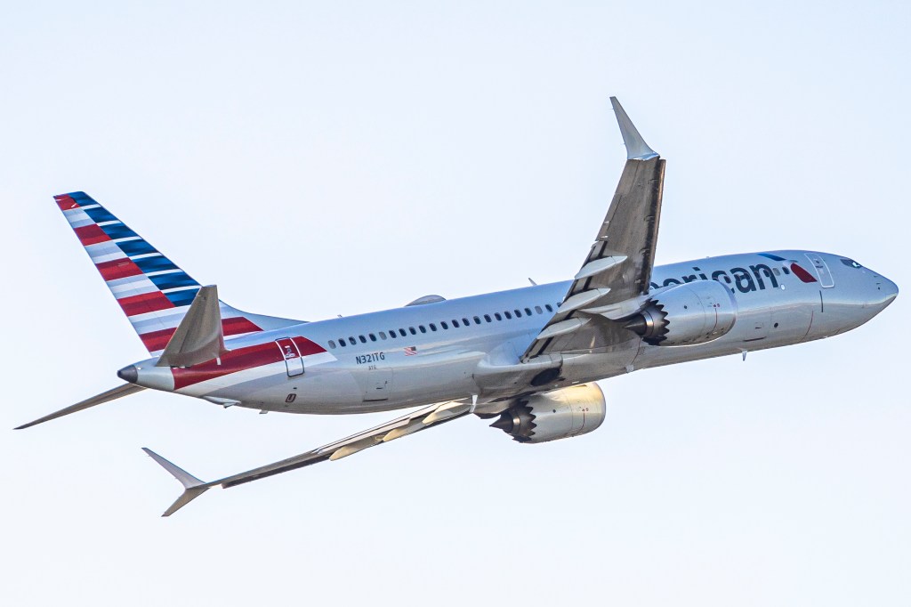 An American Airlines Boeing 737 MAX 8 passenger aircraft takes off, displaying its red, white, and blue tailfin.